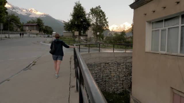 Chica-camina-por-la-ciudad-de-noche-en-las-montañas---Mestia,-Georgia