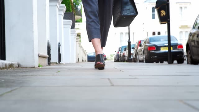 Close-Up-Of-Woman's-Feet-As-She-Walks-On-City-Pavement