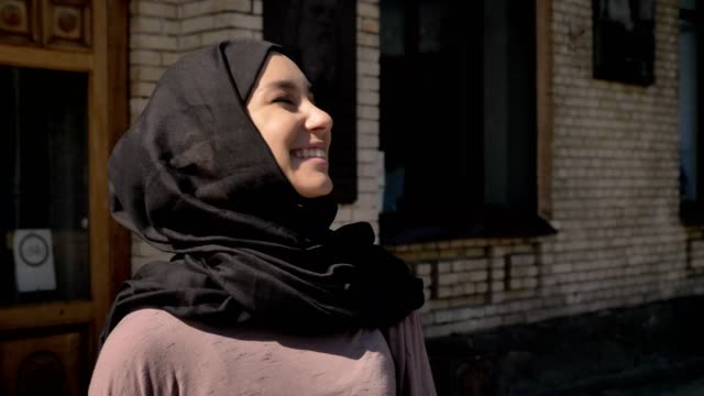 Glückliches-muslimische-Mädchen-Hijab-kommt-Universität-tagsüber-im-Sommer,-schielen,-religiöse-Konzept-aus-Studium-Konzept