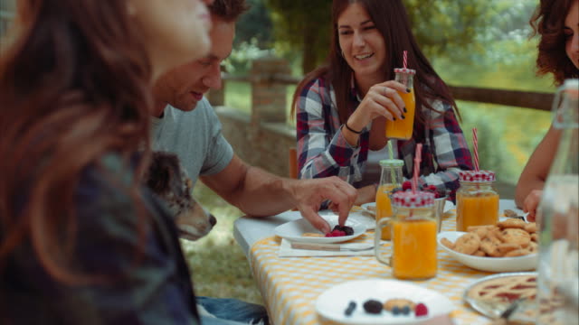 Grupo-de-amigos-haciendo-el-desayuno-al-aire-libre-en-un-paisaje-tradicional.-filmada-en-cámara-lenta
