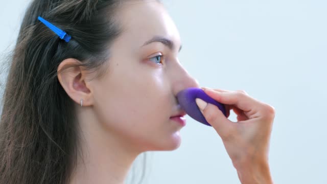 Hand-of-professional-make-up-artist-applying-tonal-cream-or-remedy-using-sponge