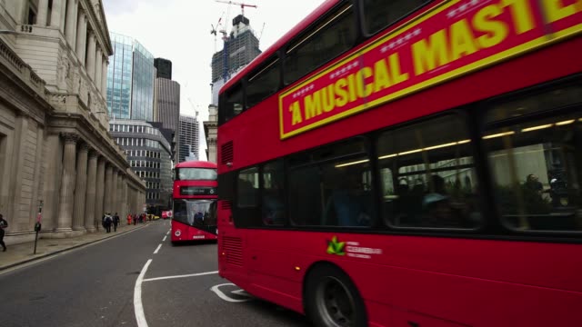 Icono-rojo-doble-autobús-pasando-durante-hora-de-acometidas-de-la-mañana-en-el-distrito-financiero-de-Londres,-Reino-Unido.