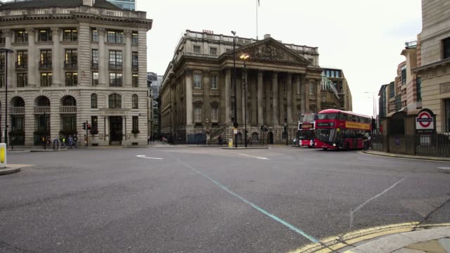 British-financial-district-with-red-double-decker-buses-and-taxis-driving-in-London,-UK.