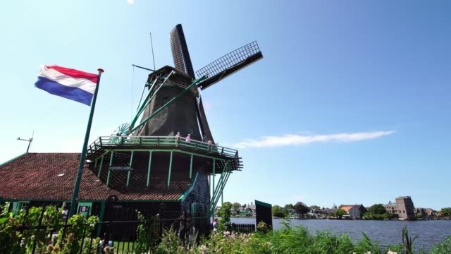 Tourist-couple-taking-pictures-of-traditional-Windmills-at-the-Zaanse-Schans-near-Amsterdam,-Holland