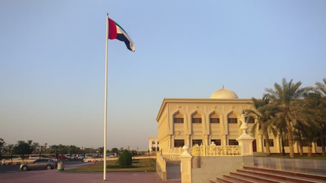 La-bandera-de-Emiratos-Árabes-Unidos-ondeando-en-la-ciudad-de-Sharjah-al-atardecer
