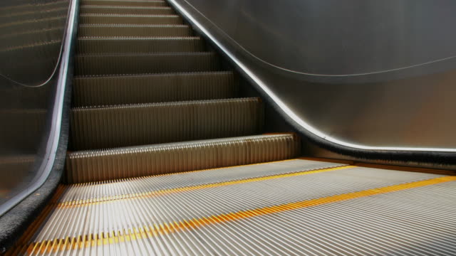 Close-shot-of-outdoor-escalator-with-parts-of-a-person-going-downwards