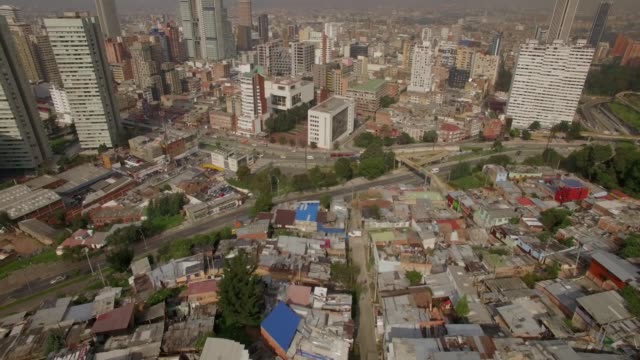 Inclinación-aérea-acercándose-a-oficinas-y-edificios-residenciales-del-centro-de-Bogotá-desde-la-ciudad-de-chabolas