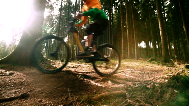 Mountain-Biker-Reiten-im-Wald-in-Zeitlupe
