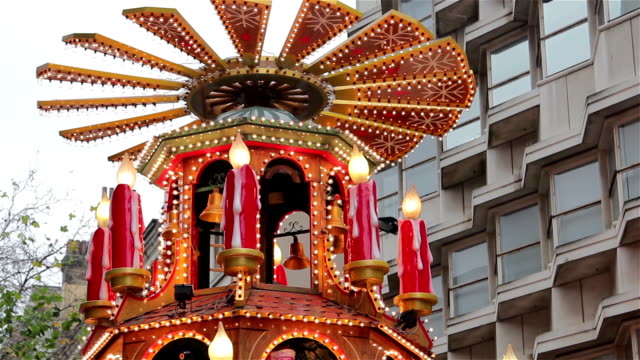 Spinning-Santa,-Xmas-Lights-Tilt---People-Enjoying-German-Christmas-Market-Stall