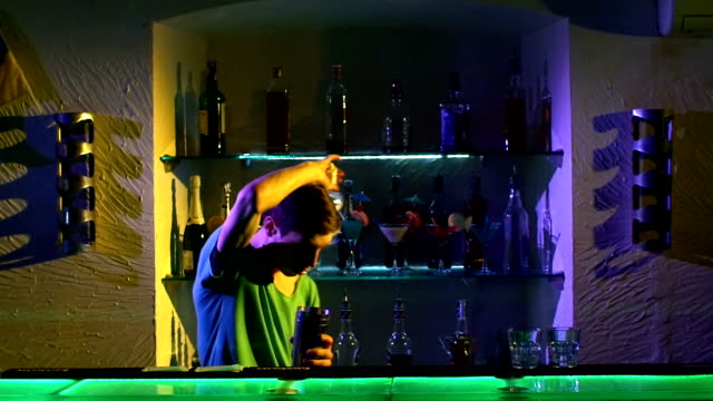 Professional-barman-making-cool,-amazing-tricks-using-shaker-and-bottle,-juggling-standing-behind-the-bar,-catching,-throwing-up,-imitation,-slow-motion