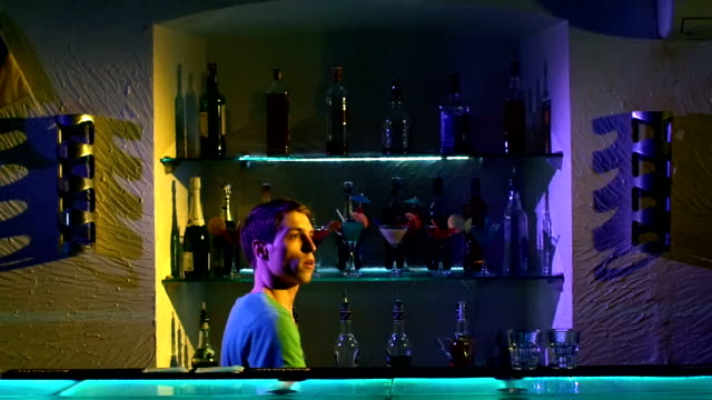 Professional-barman-making-cool,-amazing-tricks-using-three-shakers,-juggling-standing-behind-the-bar,-catching,-throwing-up,-slow-motion