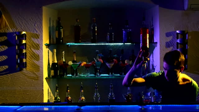 Professional-barman-making-cool,-amazing-tricks-using-bottle,-juggling-standing-behind-the-bar,-catching,-throwing-up,-and-pouring,-slow-motion