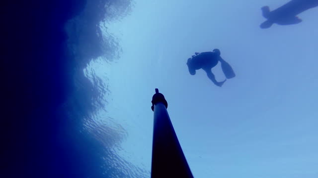 Camera-Falling-Down-and-Showing-3-Divers-on-surface