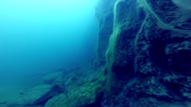 Freediver-Exploring-a-side-of-a-Underwater-Cliff-into-a-Quarry
