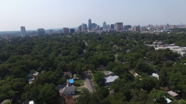 Luftbild-von-Wohnviertel-umgeben-von-viel-Grün-und-Gebäuden-im-Hintergrund-–-Austin,-Texas,-VEREINIGTE-STAATEN
