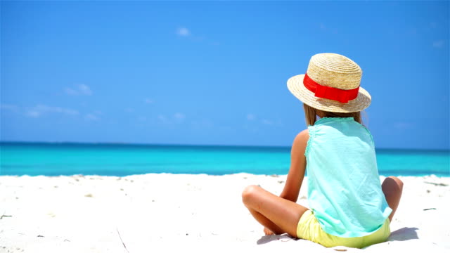Kleines-Mädchen-mit-Hut-am-Strand-im-Urlaub-in-der-Karibik