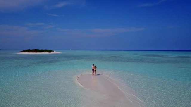v03978-fliegenden-Drohne-Luftaufnahme-der-Malediven-weißen-Sandstrand-2-Personen-junges-Paar-Mann-Frau-romantische-Liebe-auf-sonnigen-tropischen-Inselparadies-mit-Aqua-blau-Himmel-Meer-Wasser-Ozean-4k