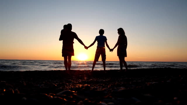 family-silhouette-at-sunset-near-the-sea-mother-dad-Kids