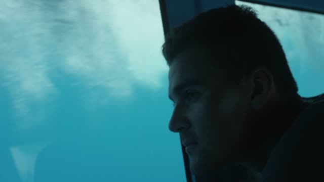 Close-up-auf-eine-Mann-Blick-auf-die-Unterwasserwelt-selbst-auf-dem-Boot-mit-dem-Glasboden.