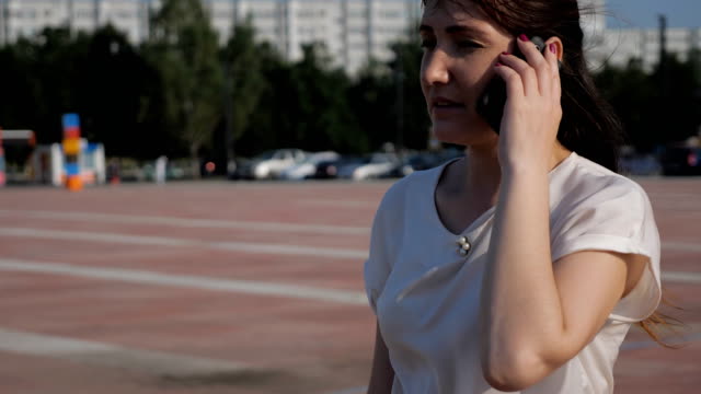 Brünette-Frau-auf-der-Straße-fällt-eine-Telefon-während-des-Gesprächs