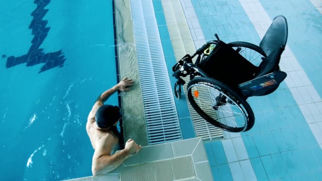 Behinderte-Mensch-steigt-aus-dem-Swimming-pool