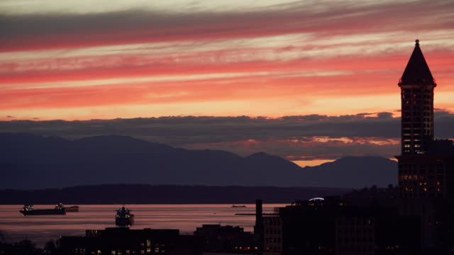 Torre-de-la-ciudad-horizonte-silueta-con-puesta-de-sol-en-vista-a-la-montaña-frente-al-mar