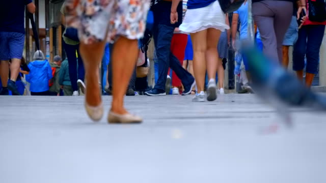 Legs-of-many-people-are-walking-along-the-sidewalk