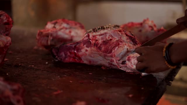 Carnicero-cortar-la-carne-de-la-cabeza-de-una-vaca-con-un-cuchillo