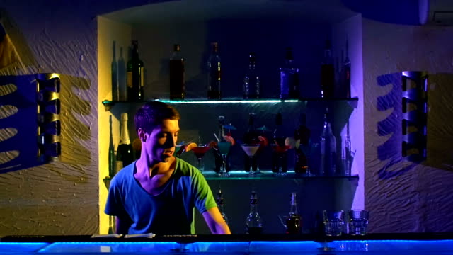 Professional-bartender-making-cool,-amazing-tricks-using-bottle-and-shaker-standing-behind-the-bar,-catching-on-arm,-throwing-up,-slow-motion