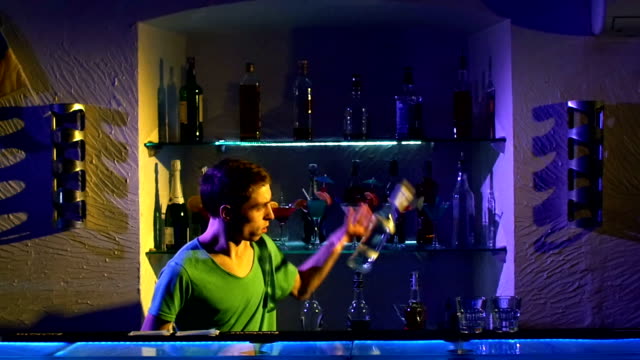 Die-professionellen-Barkeeper-cool,-erstaunlichen-tricks,-shaker-mit-zwei-Gläser-und-eine-Flasche-stehen-hinter-der-bar,-um-am-Ellbogen,-werfen,-Zeitlupe