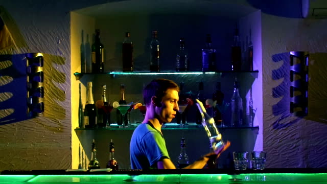 Professional-bartender-making-cool,-amazing-tricks-using-bottle-standing-behind-the-bar,-catching-on-arm,-throwing-up,-slow-motion