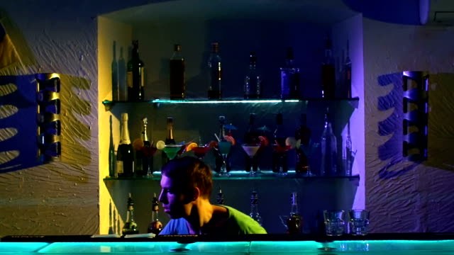 Professional-bartender-making-cool,-amazing-tricks-using-bottle-and-two-shakers-standing-behind-the-bar,-catching,-throwing-up,-slow-motion