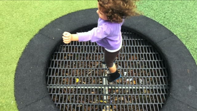 Kleines-Mädchen-springt-und-hüpft-auf-Outdoor-Trampolin