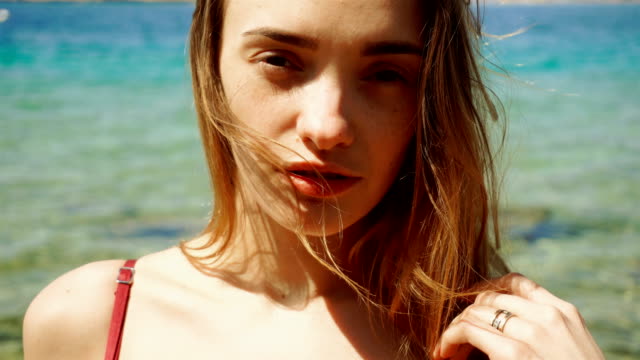 blonde-Frau-mit-Sommersprossen-im-Gesicht-posiert-am-Strand