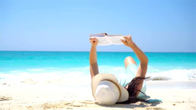 Junge-Frau-liest-auf-tropischen-weißen-Strand