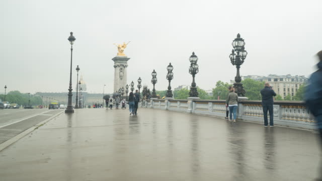 Gente-caminando-sobre-el-puente-de-Alexandre-III-en-un-día-rainny