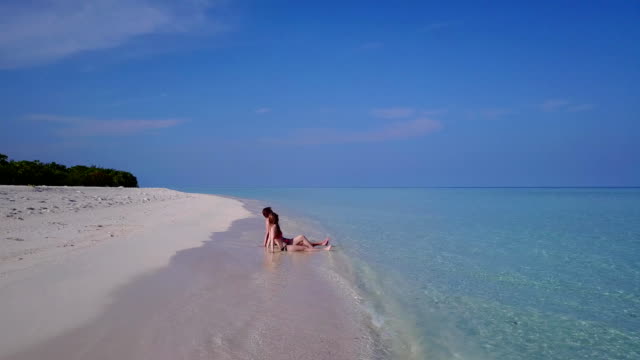 v03871-fliegenden-Drohne-Luftaufnahme-der-Malediven-weißen-Sandstrand-2-Personen-junges-Paar-Mann-Frau-romantische-Liebe-auf-sonnigen-tropischen-Inselparadies-mit-Aqua-blau-Himmel-Meer-Wasser-Ozean-4k