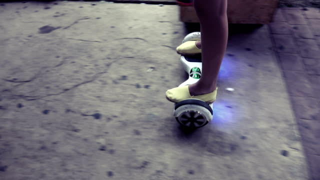 Chica-montar-en-scooter-eléctrico-hoveboard-en-la-noche-en-pasarela