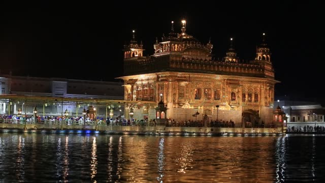 Sikhs-y-gente-India-visitando-el-templo-dorado-en-Amritsar,-en-la-noche.-India