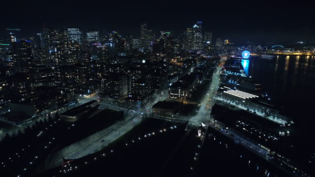 Flying-Over-City-Waterfront-at-Night-with-Tall-Buildings
