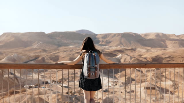 Girl-stands-at-huge-mountain-view,-arms-wide-open.-Pretty-European-woman-happy-and-excited.-Freedom.-Masada,-Israel.-4K