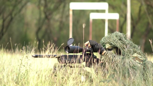 Sniper-soldier-lying-on-the-ground-and-camouflage-in-grass.-Soldier-holding-gun-weapon-and-waring-armor-uniform.-The-military-is-responsible-for-maintaining-the-territory.