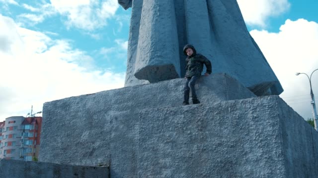 Sieben-Jahr-Alter-Junge-klettert-der-Sockel-des-Denkmals.-Parkour-in-der-Stadt.