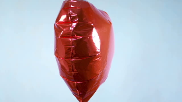 Rotes-herzballon-auf-blauem-Hintergrund
