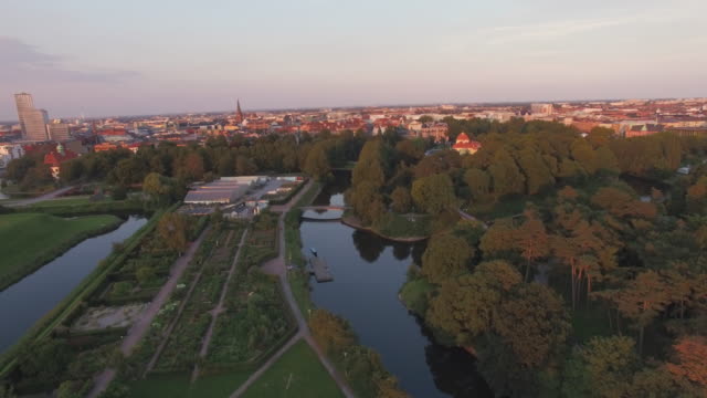 Vista-aérea-volando-sobre-el-paisaje-urbano-de-Malmö-al-atardecer.-Drone-tiro-de-\"Malmohus\"-en-Suecia,-Turning-Torso-en-el-fondo