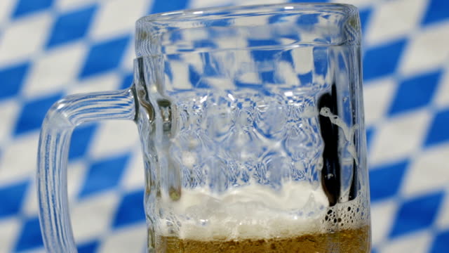 close-up-of-beer-mug-pouring-beer-into-in-front-of-the-bavarian-flag