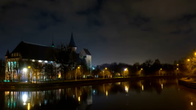 Illumination-on-a-historic-building.-Historic-Landmark.-Time-lapse.-Cathedral-of-Kant-in-Kaliningrad.-Old-medieval-at-night-against-the-sky.-Timelapse.-City-park-with-a-river,-a-pond.