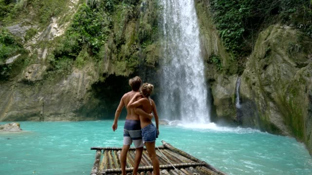 Junges-Paar-wird-zärtlich-an-wunderschönen-tropischen-Wasserfall-auf-den-Philippinen-Urlaub-und-Freiheit-genießen.-Reisekonzept-Liebe-Menschen