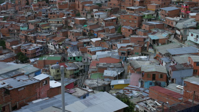 Ansicht-der-Nachbarschaft-in-\"Comuna-13\"-Medellin-Kolumbien-mit-Stadtzentrum-im-Hintergrund,-kippen-oben