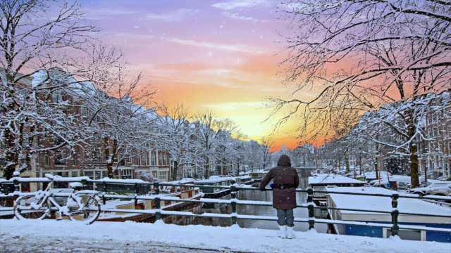 Malerische-Stadt-von-verschneiten-Amsterdam-in-den-Niederlanden-bei-Sonnenuntergang